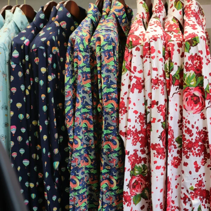 Shirts with unique patterns hang on display.
